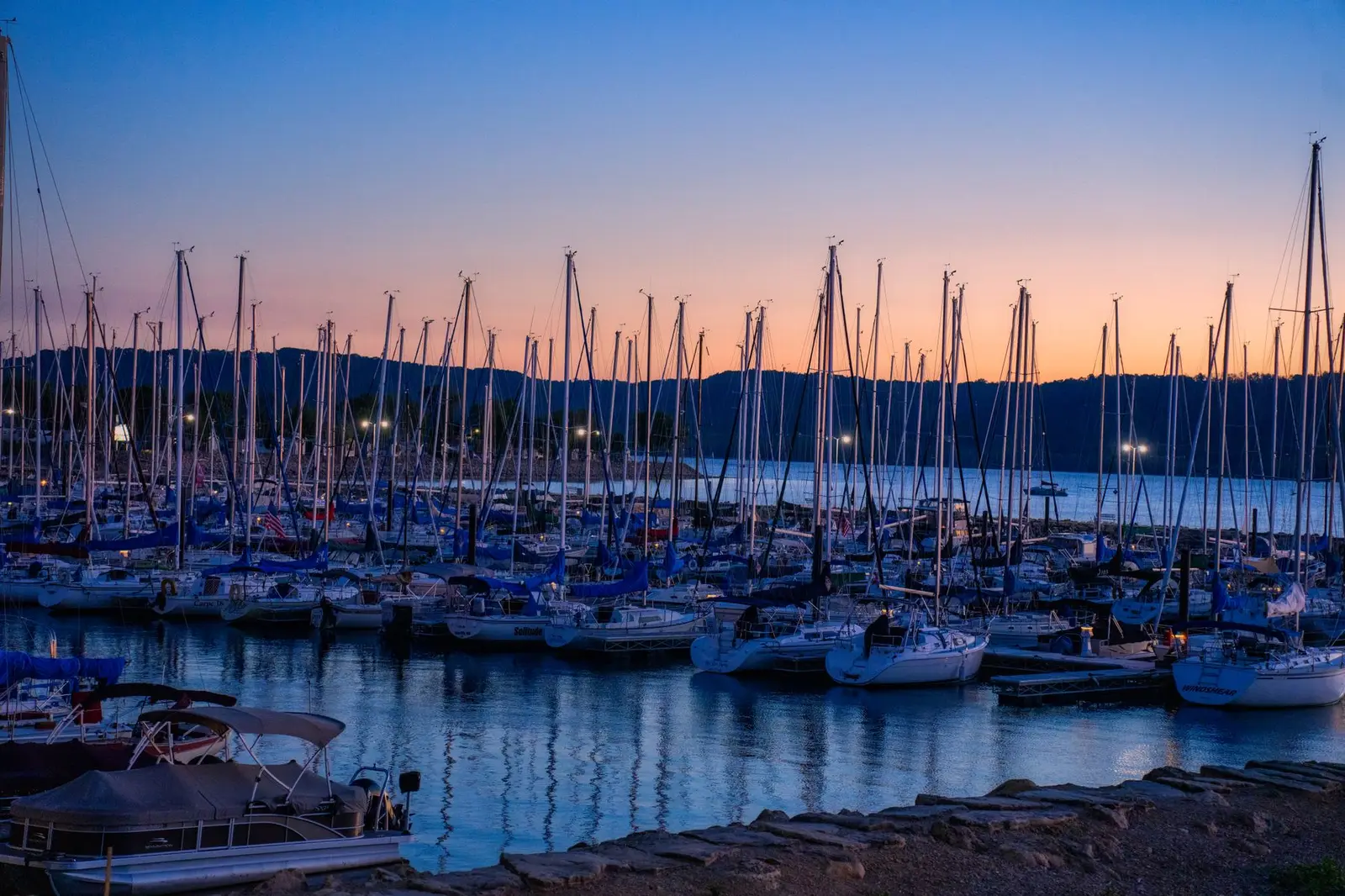 Yachts moored in a marina at sunset